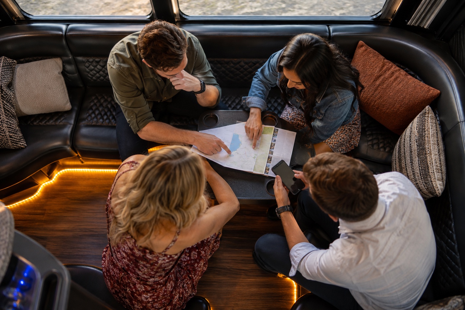 Overhead view of friends planning their outing around a table in a bus lounge